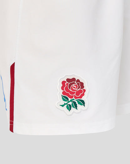 Close-up of a white sports jersey with a red rose emblem on a light gray background