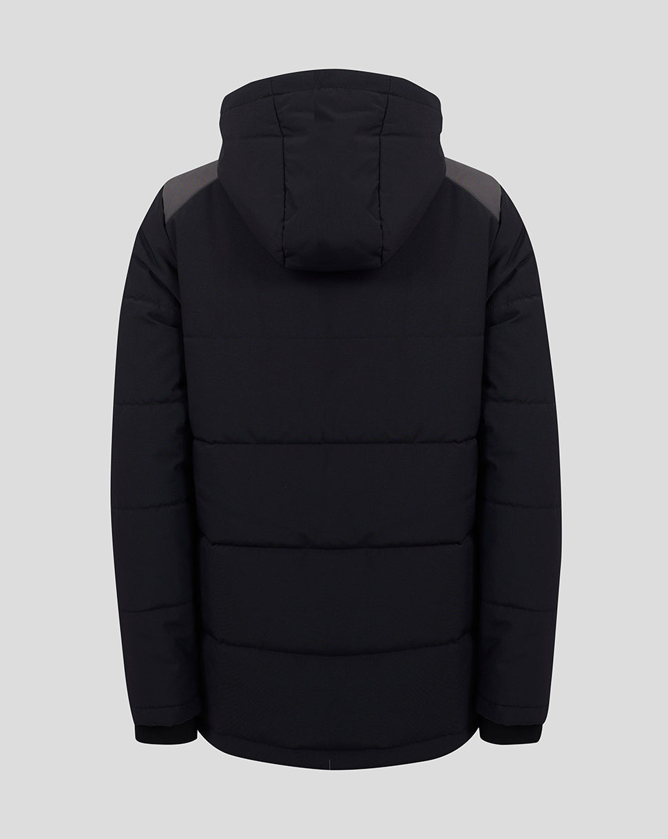 A black hooded puffer jacket shown from the back, featuring horizontal quilting and contrasting dark gray shoulder panels, set against a solid light gray background.