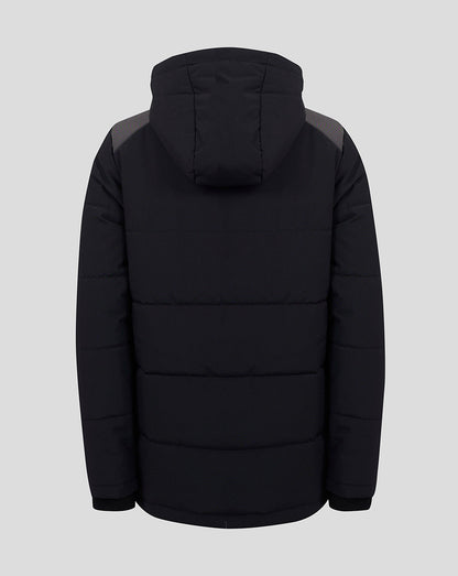 A black hooded puffer jacket shown from the back, featuring horizontal quilting and contrasting dark gray shoulder panels, set against a solid light gray background.