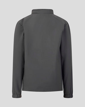 A dark gray long-sleeve jacket shown from the back, featuring a high collar and subtle shoulder seam details, set against a solid light gray background.