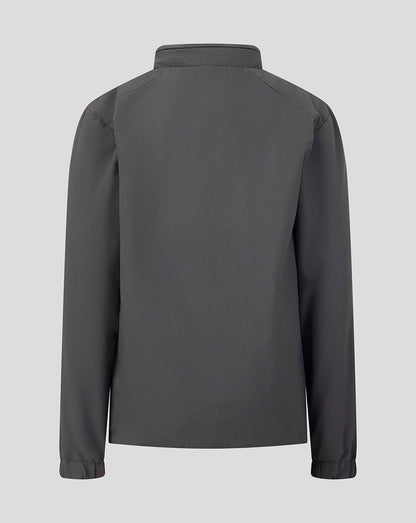 A dark gray long-sleeve jacket shown from the back, featuring a high collar and subtle shoulder seam details, set against a solid light gray background.