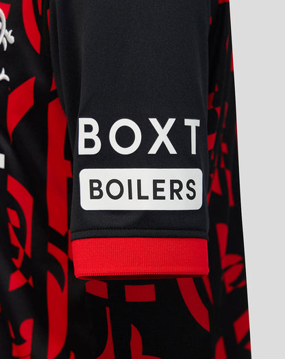 Close-up of a black long-sleeve top with a red abstract pattern, featuring a white sleeve patch that reads 'BOXT BOILERS' and a red ribbed cuff.