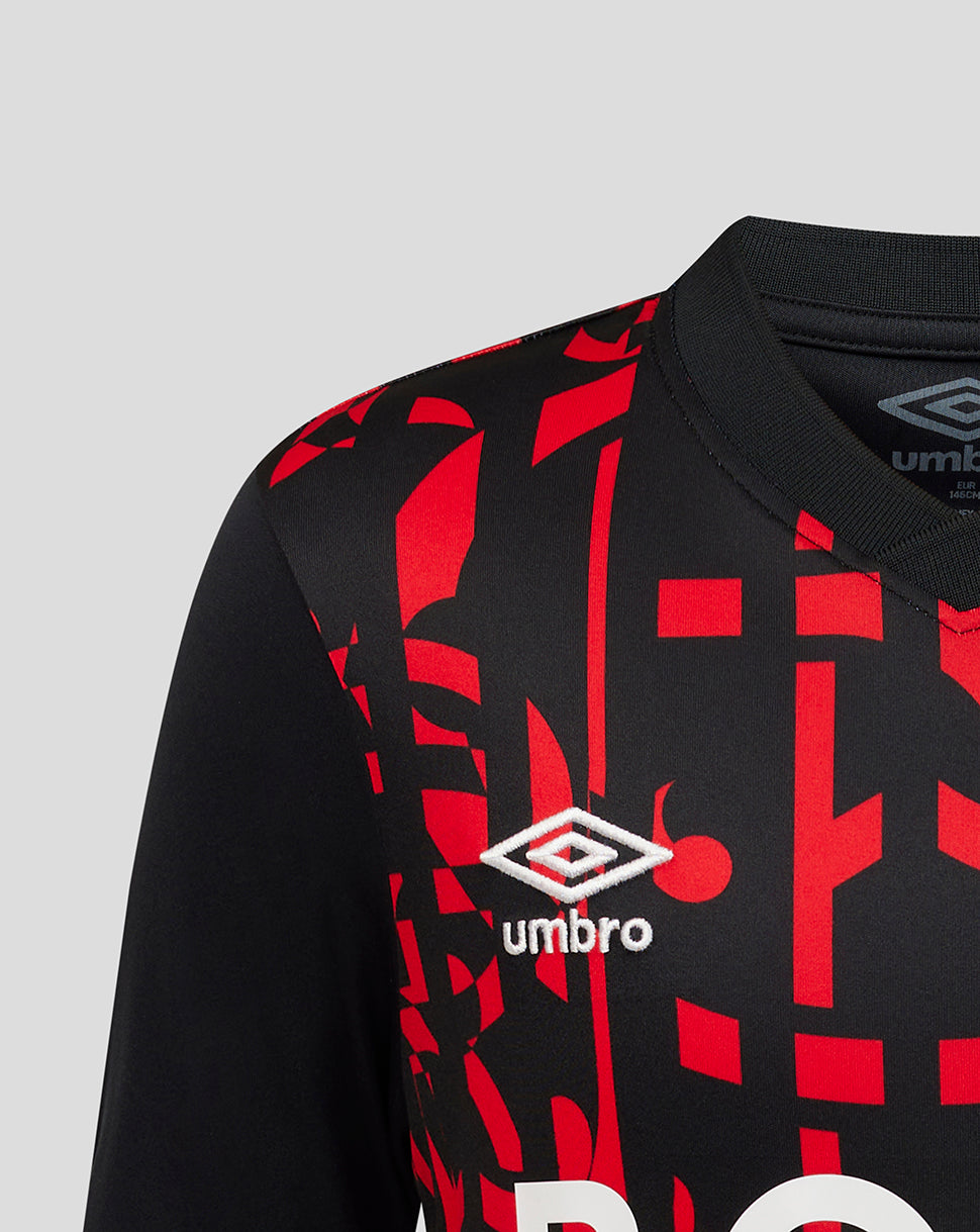 Close-up of a black soccer jersey with a red geometric pattern and the white Umbro logo on the chest.