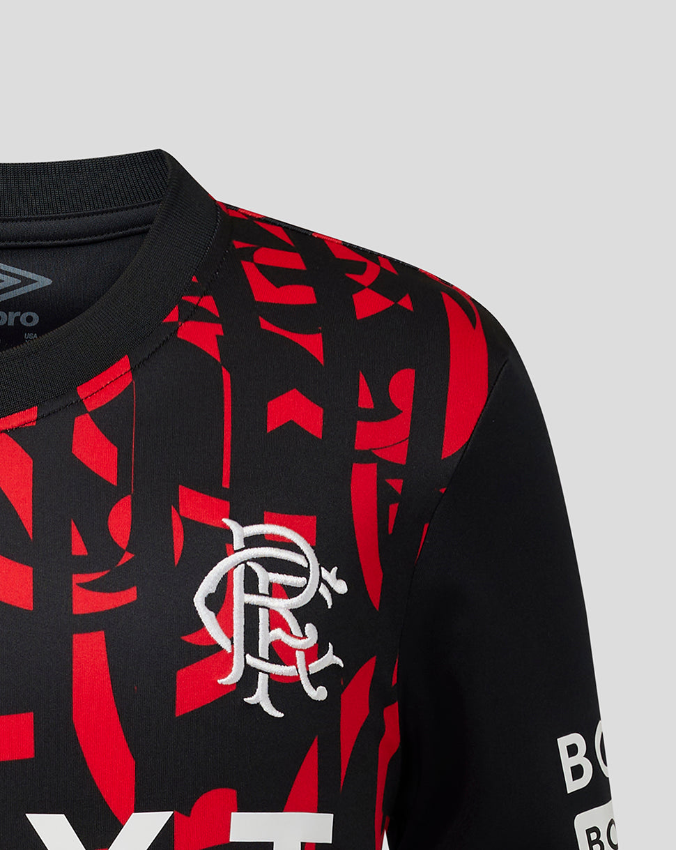 Close-up of a black and red patterned football jersey with the club's white crest on the chest, photographed against a light gray background.