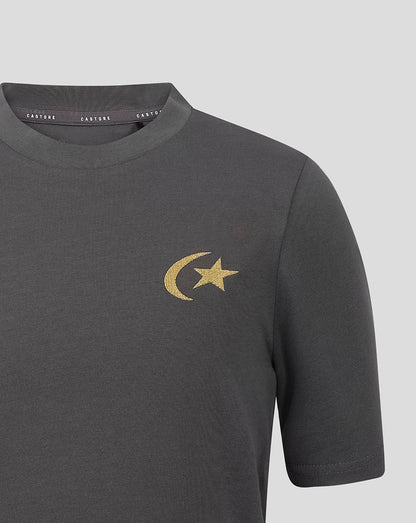 A close-up of a dark gray crewneck t-shirt featuring a gold embroidered crescent moon and star logo on the left chest, with the brand name 'castore' visible on the inner neck label.