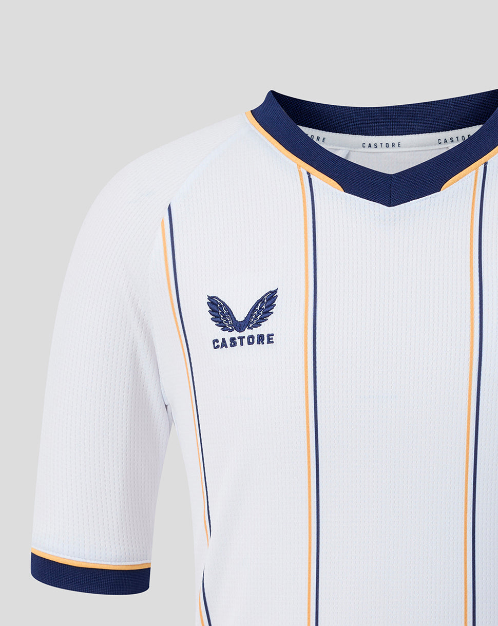Close up of Everton junior away shirt chest showing crest and navy blue and gold piping on white fabric