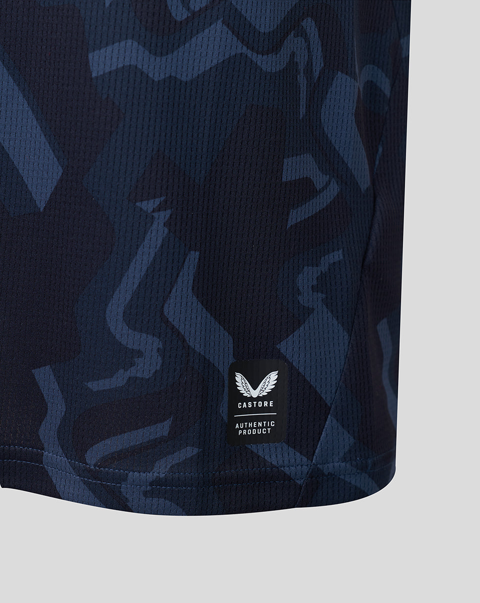 Lower front close up of navy camouflage Feyenoord shirt showing left chest crest and Castore authentic product label near the hem.