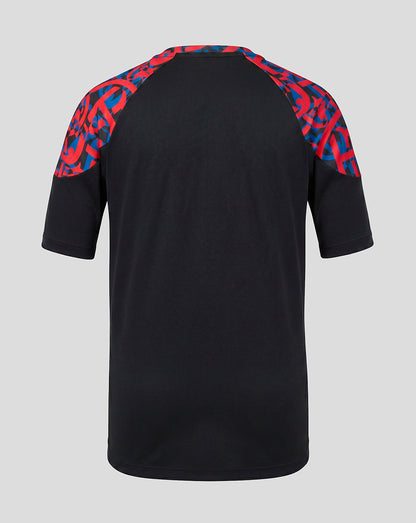 A black short-sleeve raglan t-shirt shown from the back, featuring a vibrant red and blue geometric pattern on the shoulders, set against a solid light gray background.