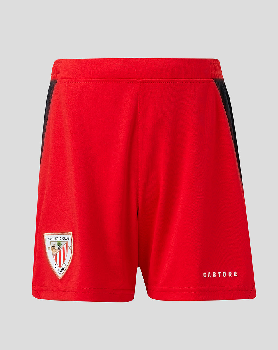 Front view of red Athletic Club junior away shorts with the club crest on the left leg and Castore branding on the right.
