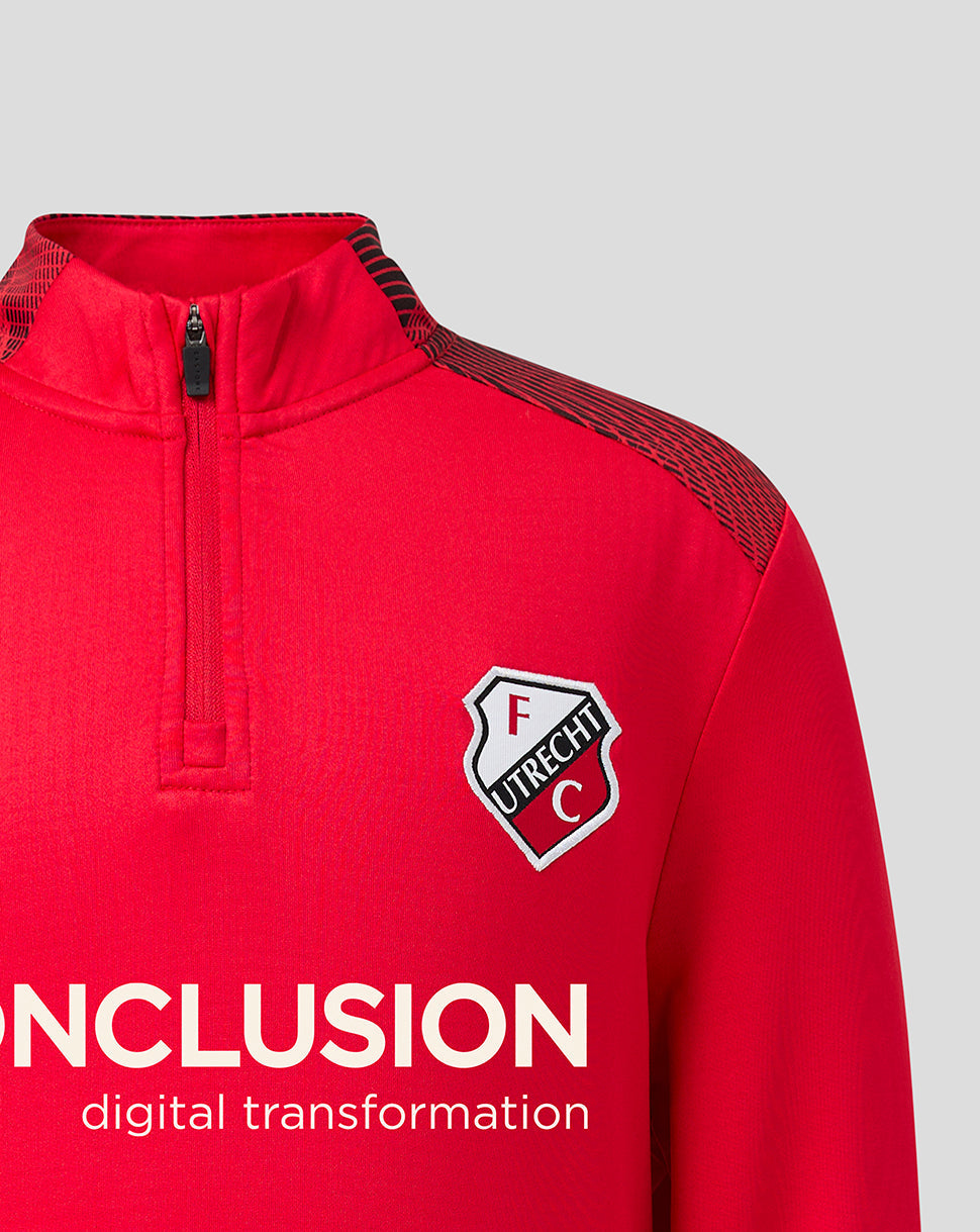 Bright red FC Utrecht matchday midlayer with quarter zipper, black patterned shoulder panels and club crest on the left chest.