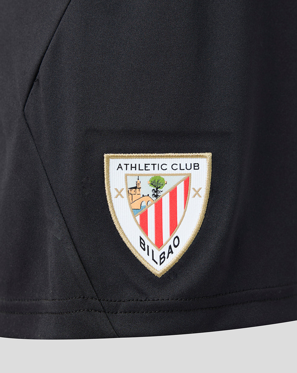 Close-up of black Athletic Club Junior goalkeeper shorts with embroidered club crest patch.