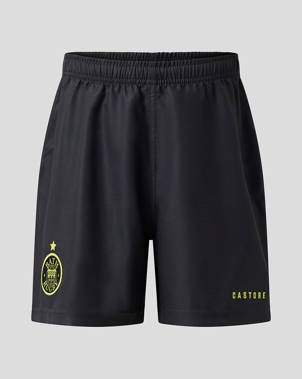Black athletic shorts with a yellow Castore logo on the left leg and a yellow crest on the right leg, shown against a light gray background.