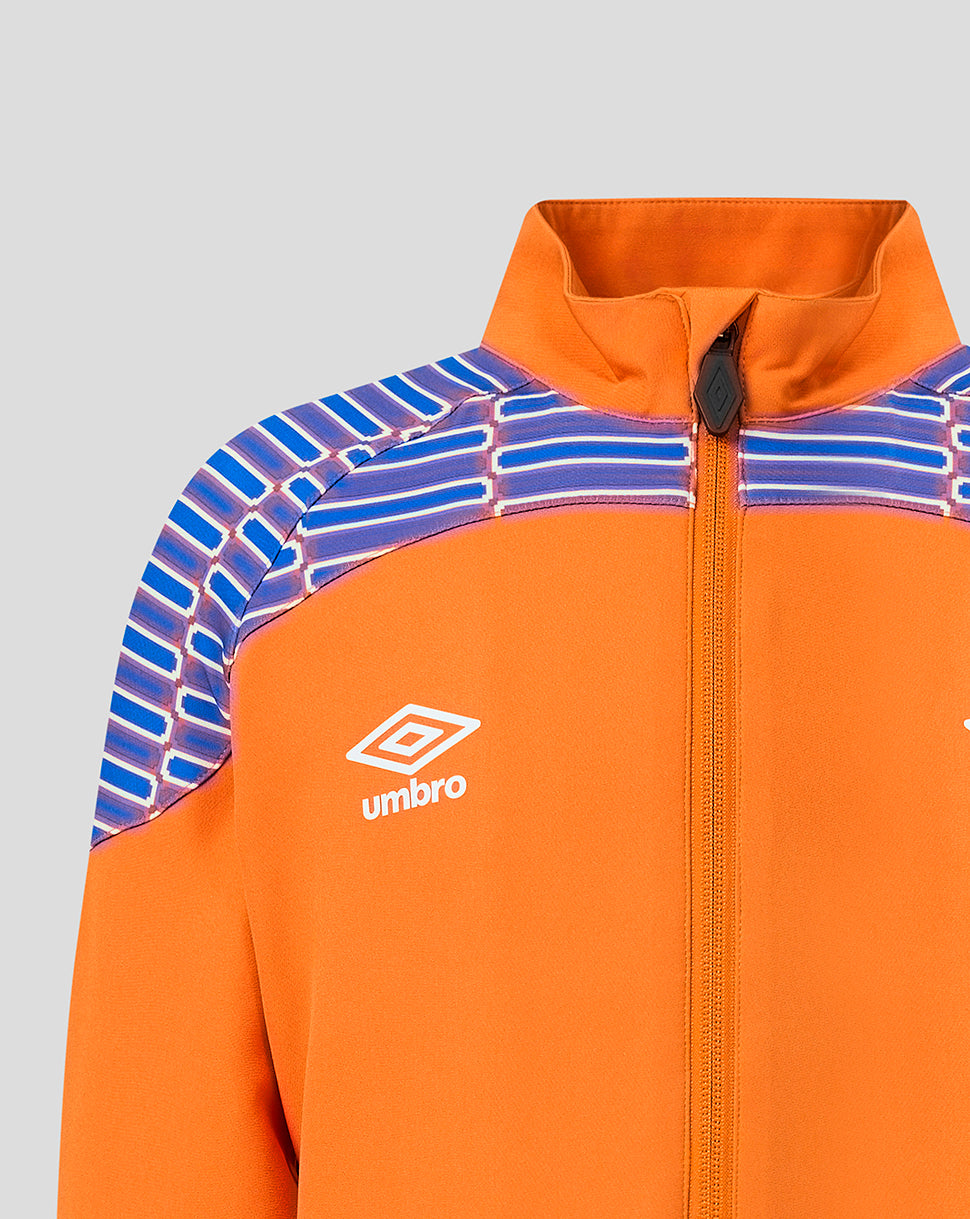 Close-up of an orange zip-up jacket with a high collar, featuring a white Umbro logo on the chest and a blue and white patterned yoke across the shoulders, shown against a light gray background.