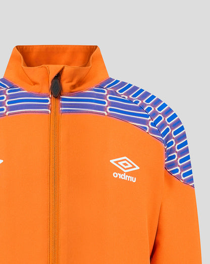 Close-up of an orange zip-up jacket with blue and white patterned shoulder panels and a white Umbro logo on the chest, shown against a light gray background.