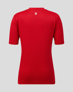 Red polo shirt with a logo on the back against a gray background
