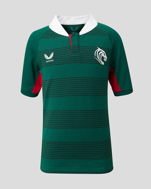 A green short-sleeve rugby jersey with horizontal dark stripes, a white collar, red side panels, and white embroidered logos on the chest, shown against a solid gray background.