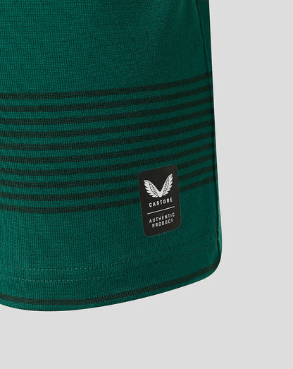Close-up of a dark green knit garment with horizontal black stripes and a black Castore Authentic Product patch on the side, shown against a light gray background.