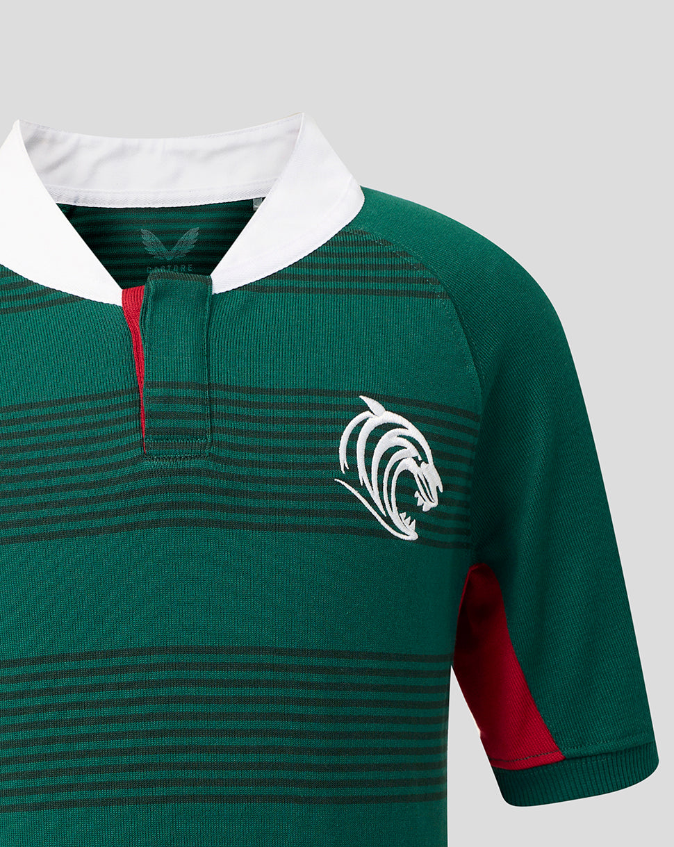 Close-up of a green rugby jersey with thin horizontal dark stripes, a white collar, a red placket accent, and a white animal head logo on the chest.