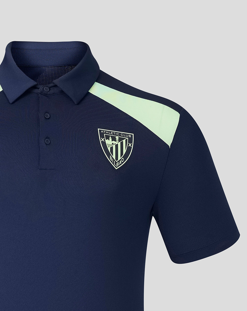 Close-up of navy polo with mint shoulder stripe and crest on left chest