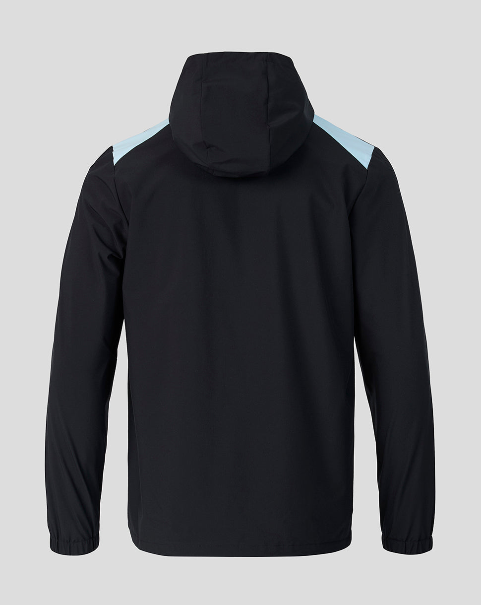 Back view of Feyenoord training rain jacket in black with light blue shoulder panels and hood