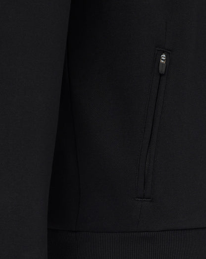 Close-up of a black hoodie with a brand logo on the chest pocket against a dark background.