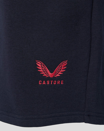 Close-up of red Castore logo embroidered on navy FC Twente travel fleece shorts fabric.