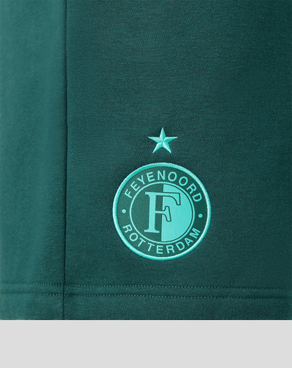 Close-up of green shorts fabric showing the Feyenoord Rotterdam crest embroidery with a star above.
