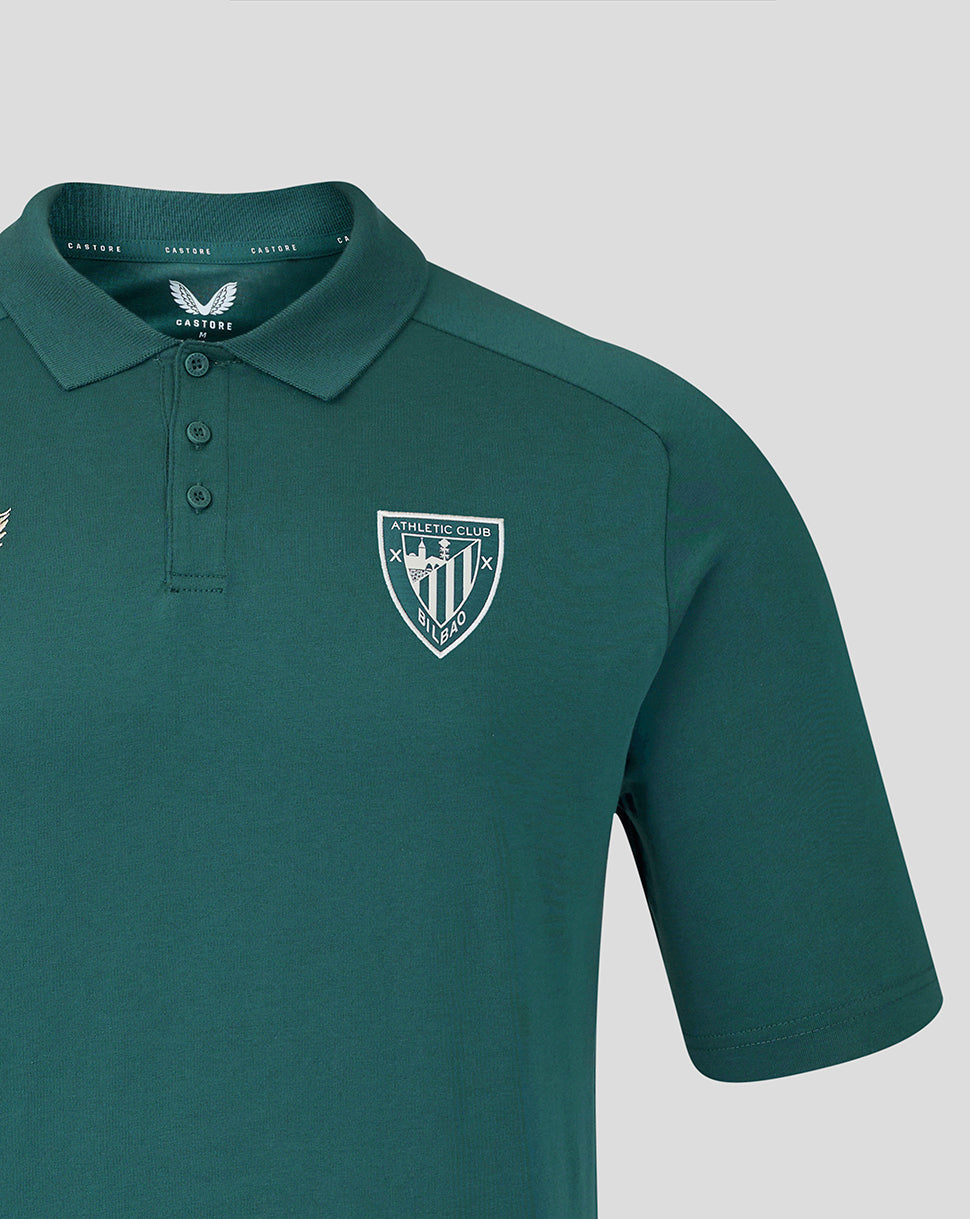 Close up of teal polo chest showing the Athletic Club crest and Castore branding.
