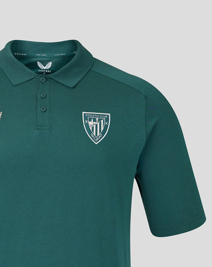 Close up of teal polo chest showing the Athletic Club crest and Castore branding.