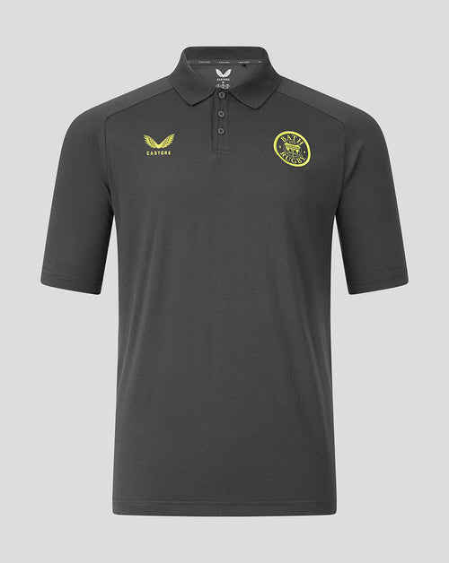 A dark gray short-sleeve polo shirt with a yellow Castore logo on the right chest and a yellow circular club crest on the left chest, displayed against a solid gray background.