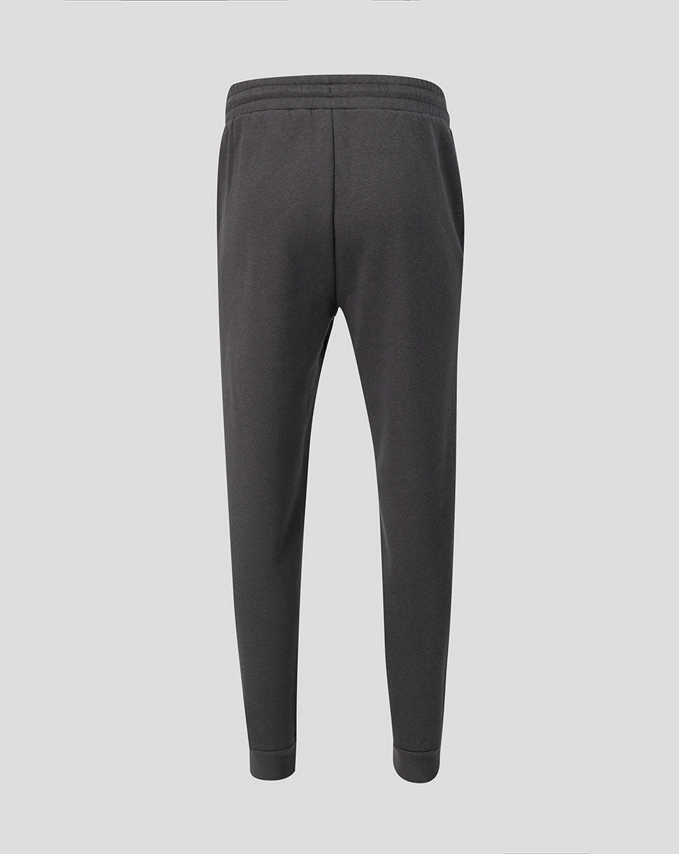 Back view of dark grey travel fleece pants with elastic waistband and Castore wing logo on the hip