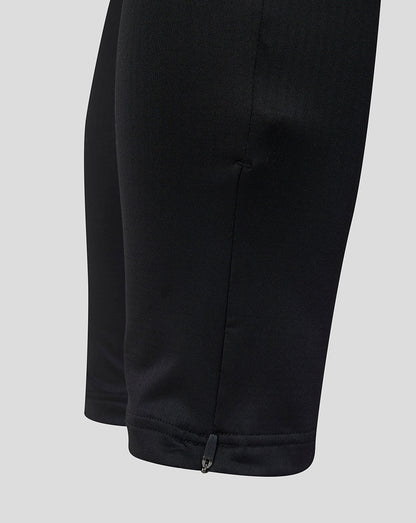Close-up of the ankle area on black training coaches pants with a small zipper detail