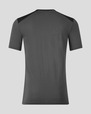 A dark gray athletic t-shirt shown from the back, featuring solid dark gray fabric with contrasting black shoulder panels, displayed on a neutral light gray background.