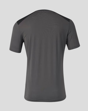 A dark gray athletic t-shirt shown from the back, featuring subtle wavy texture and contrasting dark shoulder panels, set against a solid light gray background.