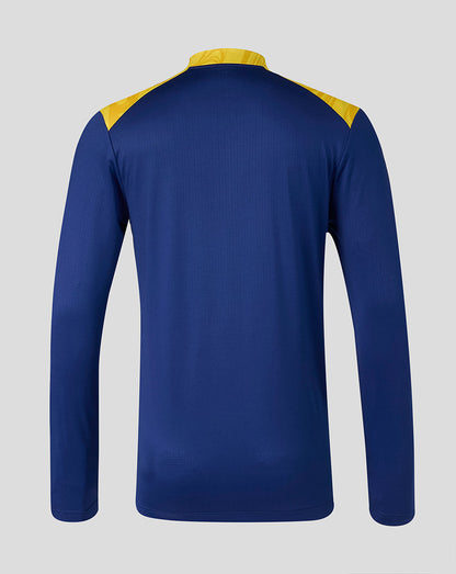 Blue long-sleeve shirt with yellow accents on a gray background