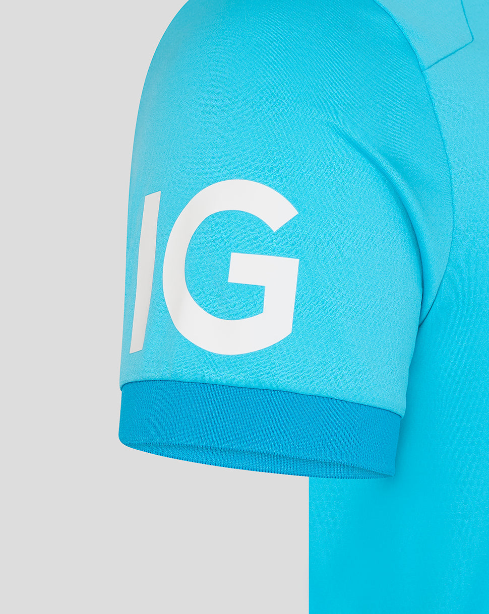 Close-up of a blue shirt with a large white 'IG' logo on a light gray background