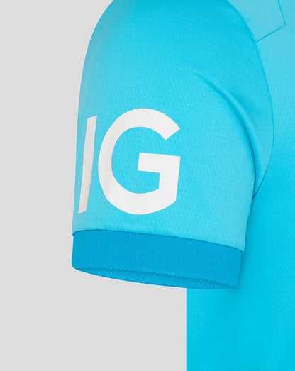 Close-up of a blue shirt with a large white 'IG' logo on a light gray background