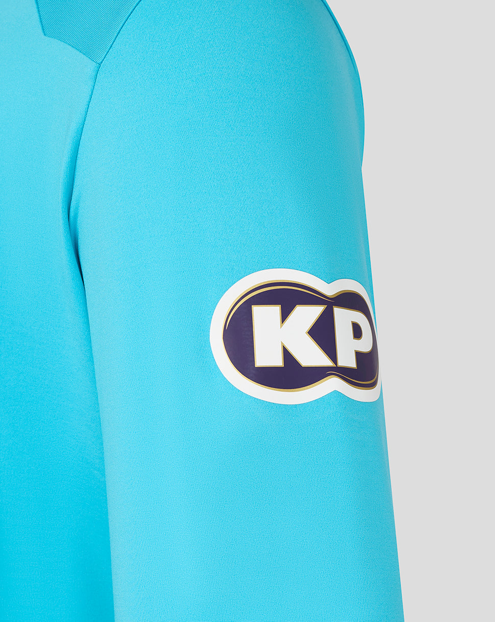 Close-up of a blue shirt with a KP logo on the sleeve against a white background