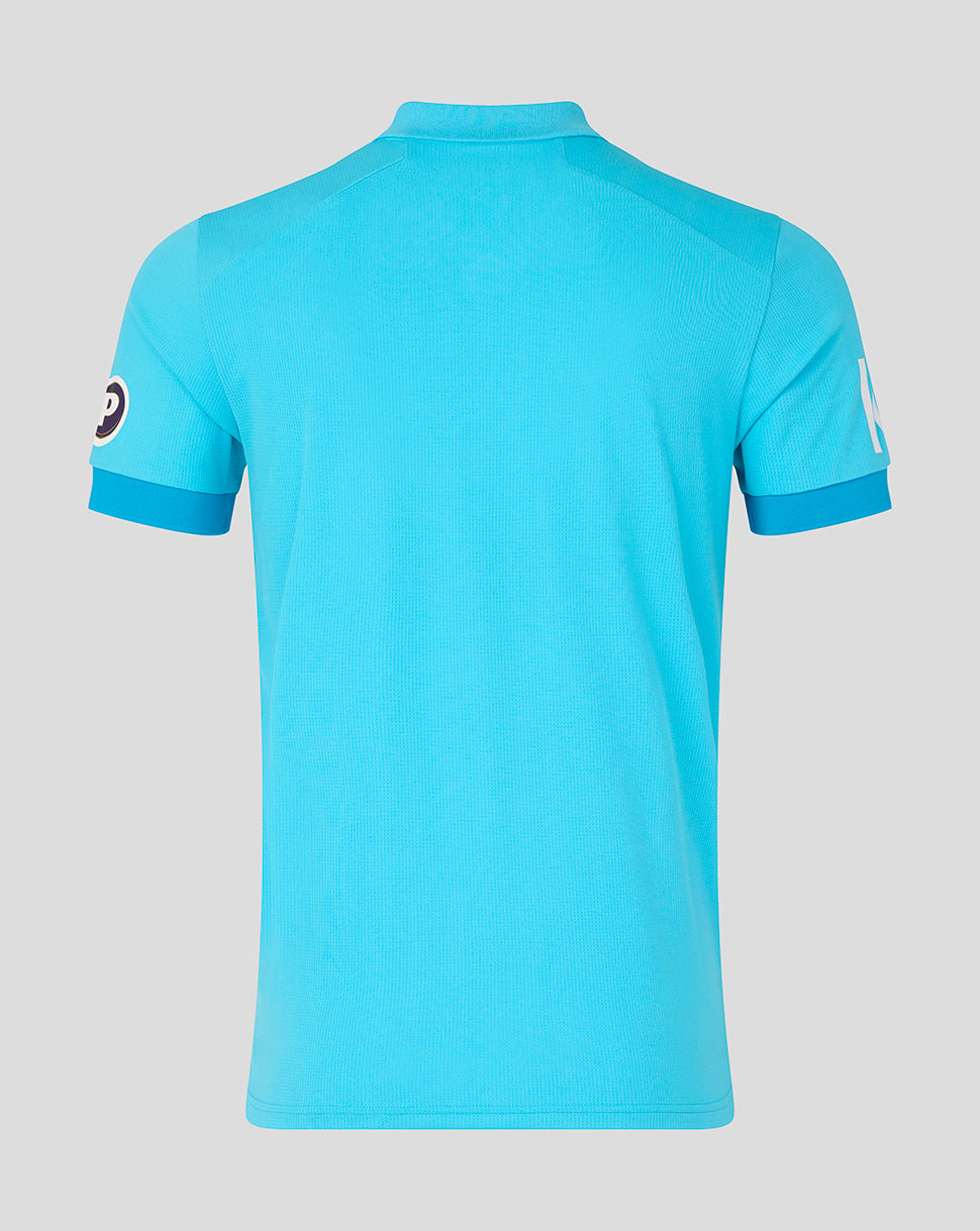Blue polo shirt with brand logo on sleeves against a gray background