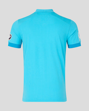Blue polo shirt with brand logo on sleeves against a gray background