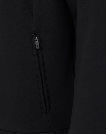Close-up of a black hoodie with a zipper detail on a dark background