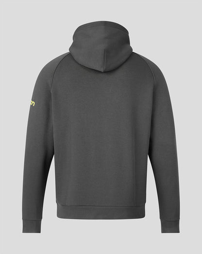 A dark gray pullover hoodie shown from the back, featuring a small yellow logo on the left sleeve, set against a solid light gray background.