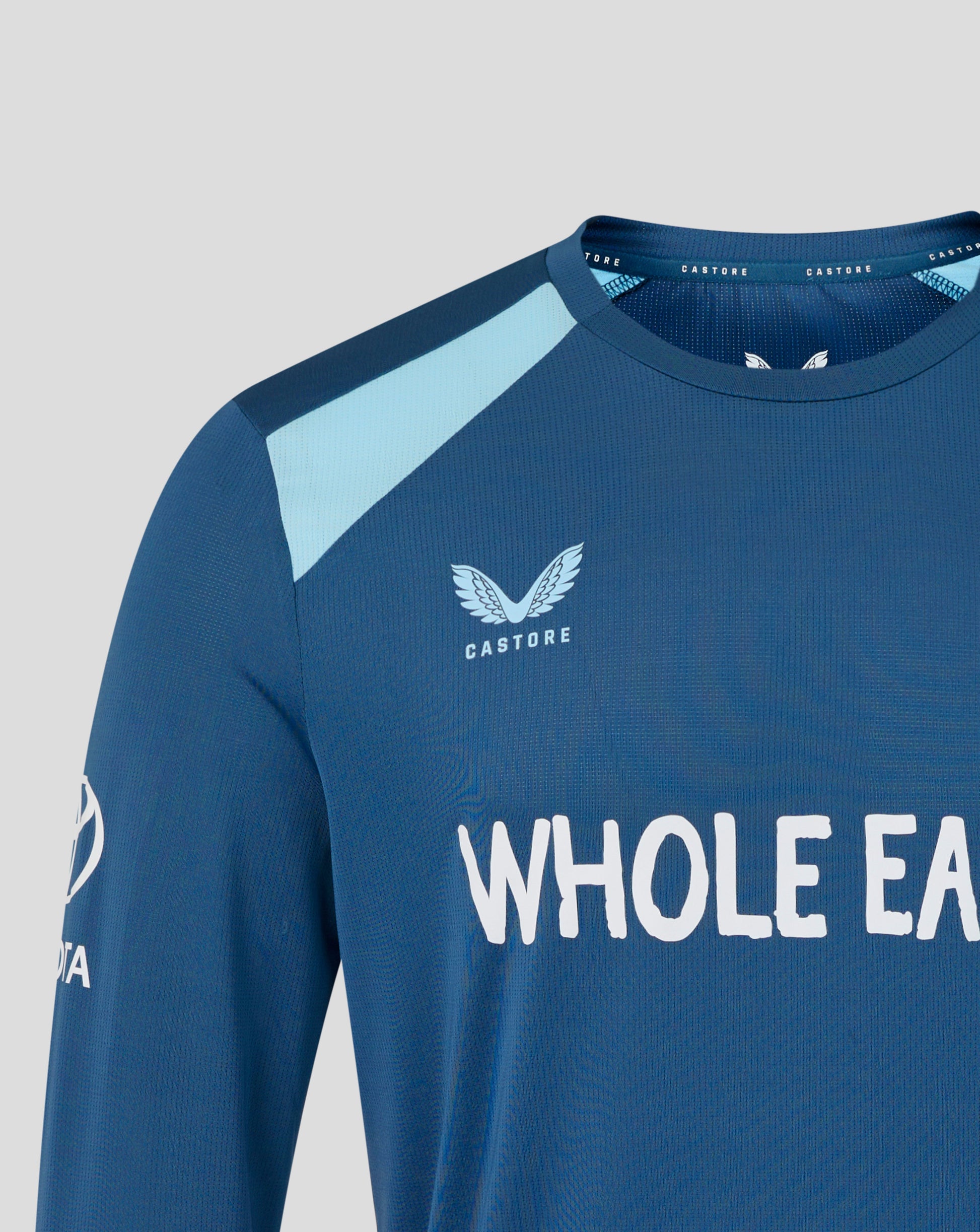 Blue athletic shirt with 'Castore' logo and text on a light gray background