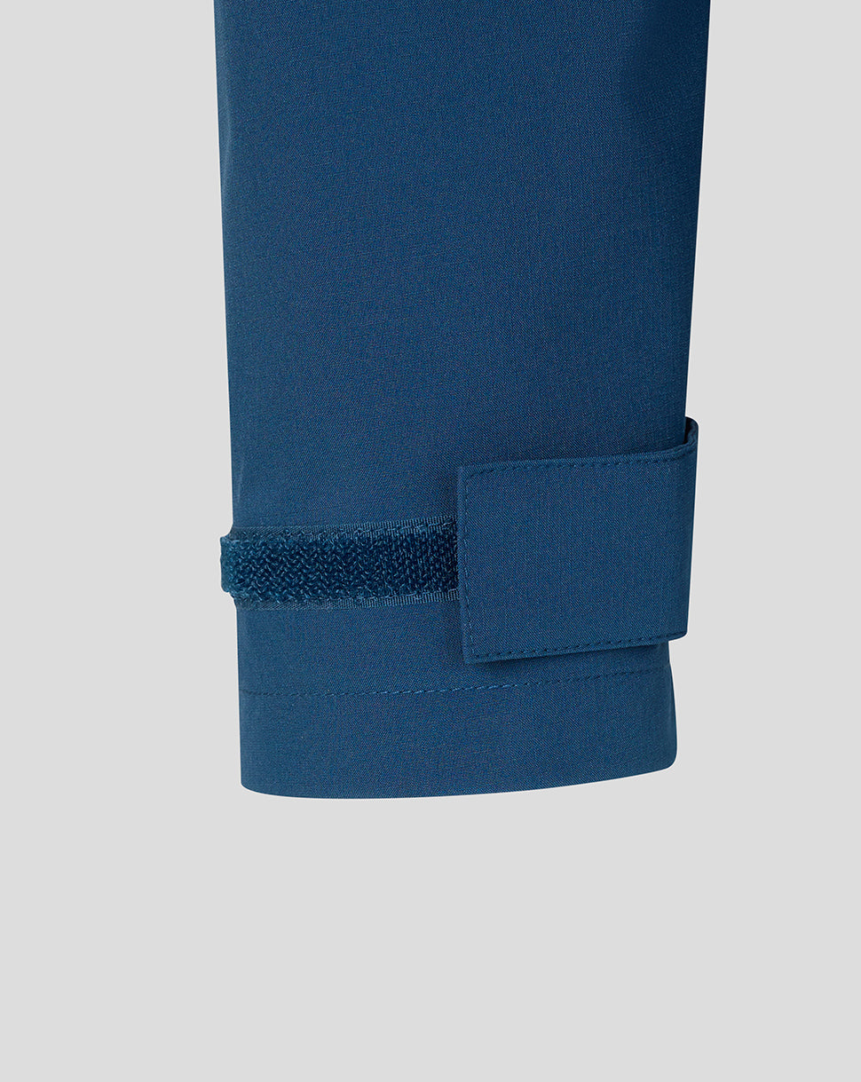 Close-up of a blue shirt with rolled-up sleeve on a light gray background