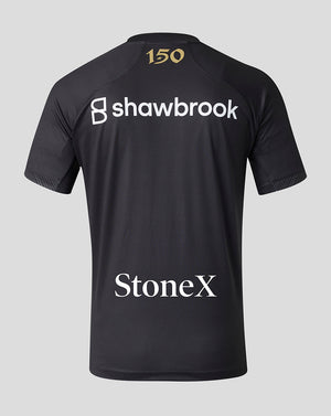 Black short-sleeve athletic jersey shown from the back, featuring a gold '150' print on the neck, a large white 'shawbrook' logo across the upper back, and 'StoneX' in white near the lower back, set against a solid light gray background.