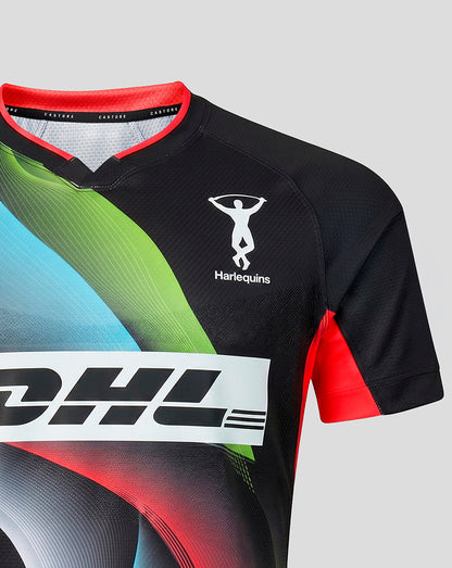 A close-up of a RUGBY jersey in black with vibrant green, blue, and red graphic accents, featuring the white Harlequins logo and a large white DHL sponsor logo across the chest.