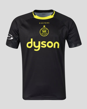 A black short-sleeve athletic jersey with a yellow collar, featuring the yellow Castore logo and Bath Rugby crest on the chest, displayed against a solid gray background.