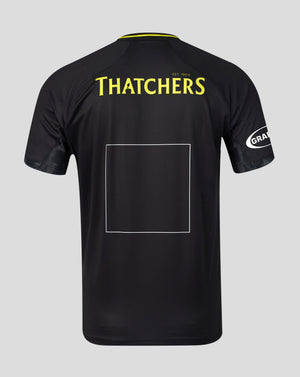 Black short-sleeve sports jersey shown from the back on a light gray background, featuring 'THATCHERS' in yellow text across the upper back, a large blank rectangular patch area in the center, and a white circular 'GRA' logo on the sleeve.