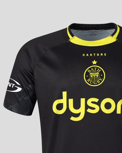 A close-up of a Bath Rugby football jersey in black with bright yellow accents, featuring the club's crest and a large 'dyson' sponsor logo on the front.
