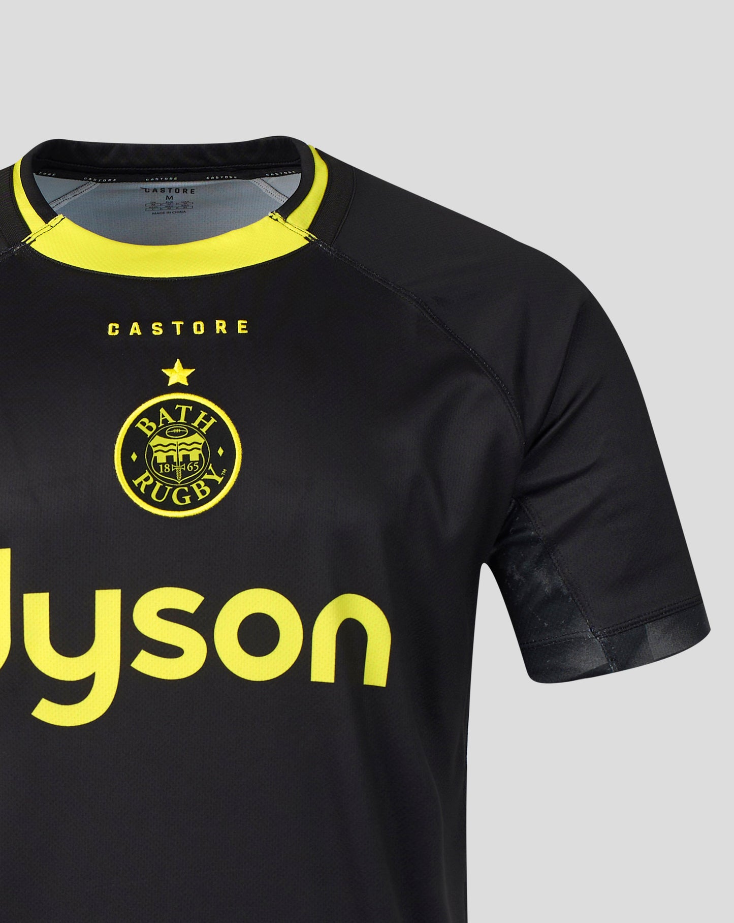 Black short-sleeve athletic jersey with a yellow collar, featuring the BATH RUGBY crest and yellow 'CASTORE' and 'Dyson' branding on a light gray background.